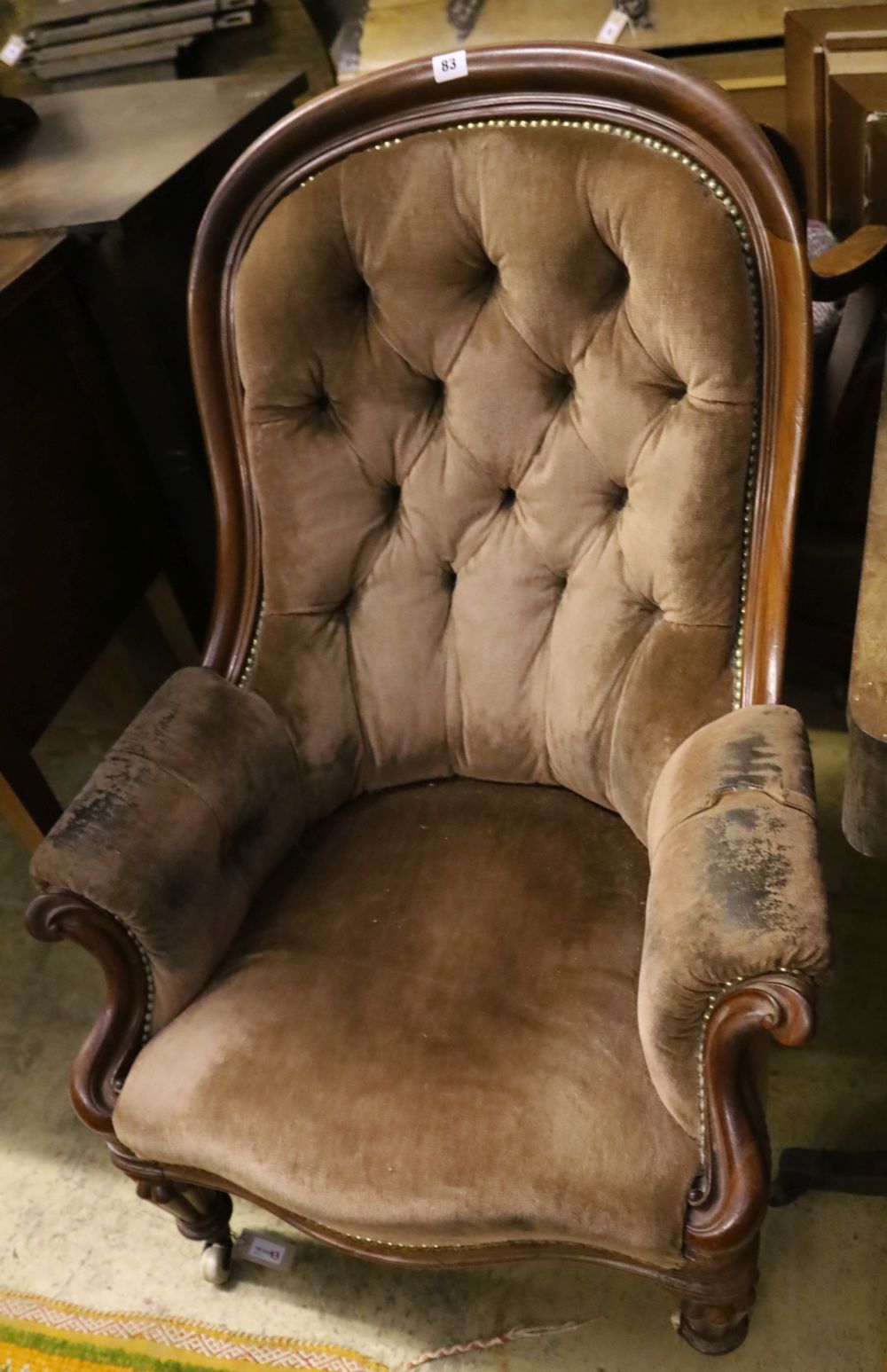 A Victorian mahogany-framed armchair covered in deep-buttoned dralon